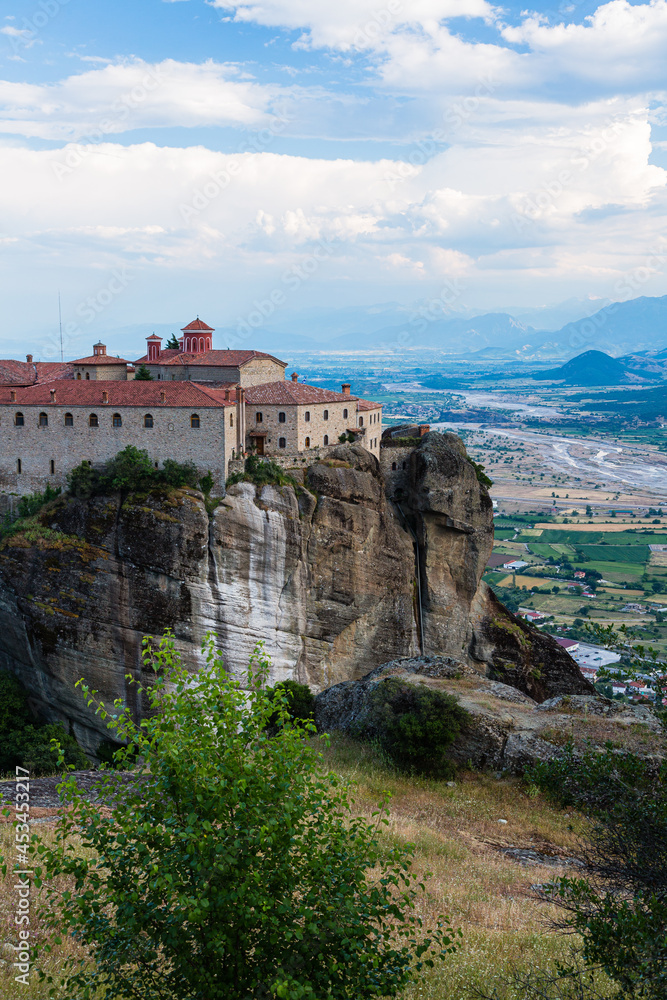 ギリシャ　メテオラの断崖絶壁の岩山の上に建つ聖ステファノス修道院と奇岩群の隙間から覗くカランバカの街並み