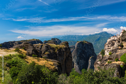 ギリシャ メテオラの断崖絶壁の岩山の上に建つヴァルラアム修道院と奇岩群と後ろに見えるピンドス山脈
