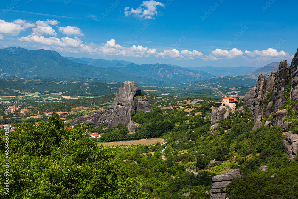 ギリシャ　メテオラの断崖絶壁の岩山の上に建つ聖ニコラオス・アナパフサス修道院と後ろに広がるピンドス山脈