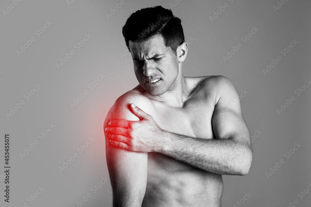 Man suffering from shoulder pain. Black and white photo