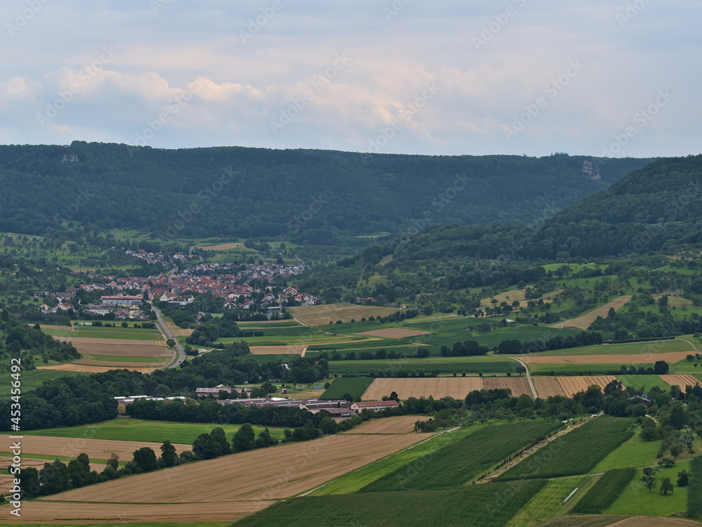 View of the northern foothills of Swabian Alb with forests, agricultural fields, rural village Hepsisau, part of Weilheim an der Teck, Germany.