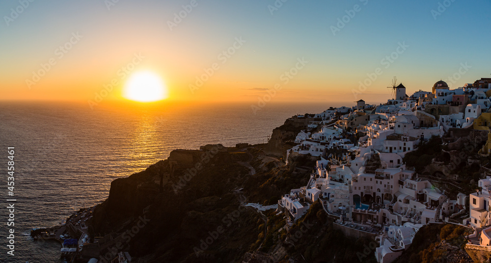 ギリシャ サントリーニ島のイアのイア・キャッスルから見えるマジックアワーの海に沈み行く夕日と白い街並みと風車 ギリシャ サントリーニ島のイアのイア・キャッスルから見えるマジックアワーの海に沈み行く夕日と白い街並みと風車