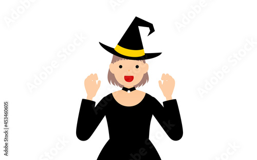 ハロウィンの仮装、魔女姿の女の子が両手を構えて驚かせるポーズ