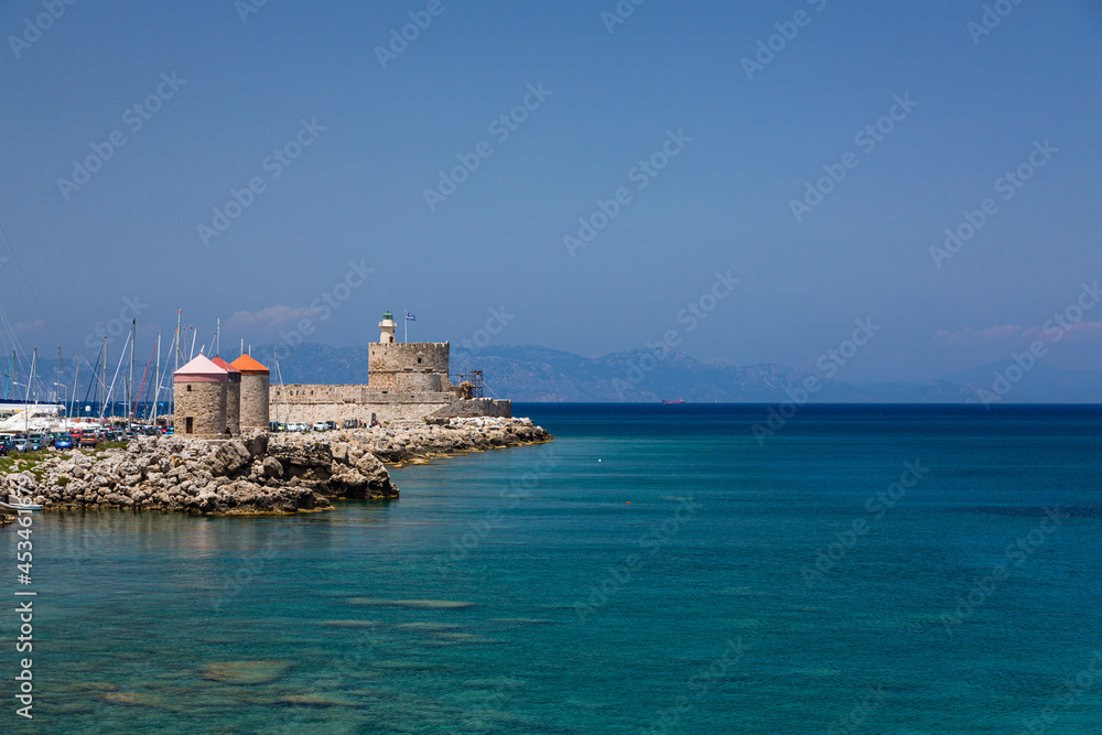 ギリシャ　ロードス島のロードスのマンドラキ港に建つ聖ニコラス要塞と風車