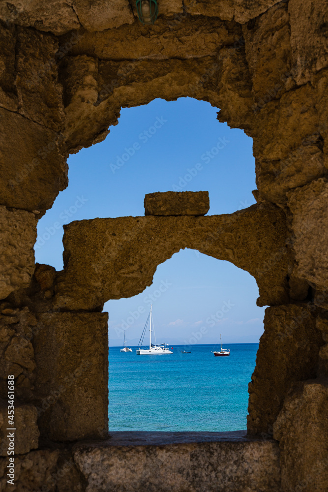 ギリシャ　ロードス島のロードスにある城壁の隙間から見えるエーゲ海とボート