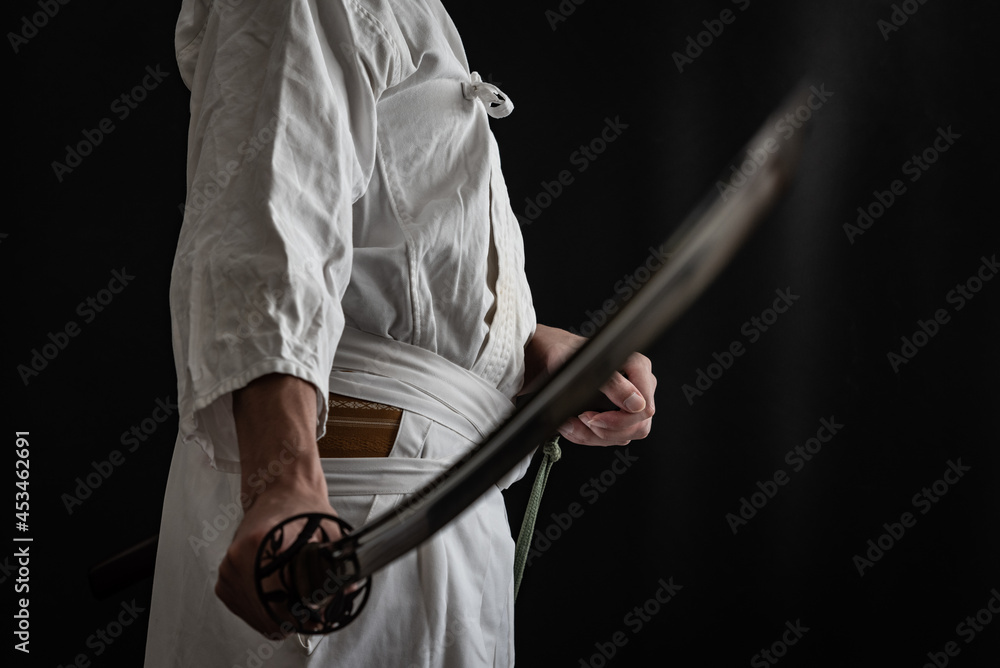 黒い背景と日本刀を構える人物