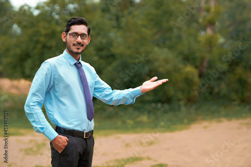 Young indian agronomist giving expresssion over nature background photo