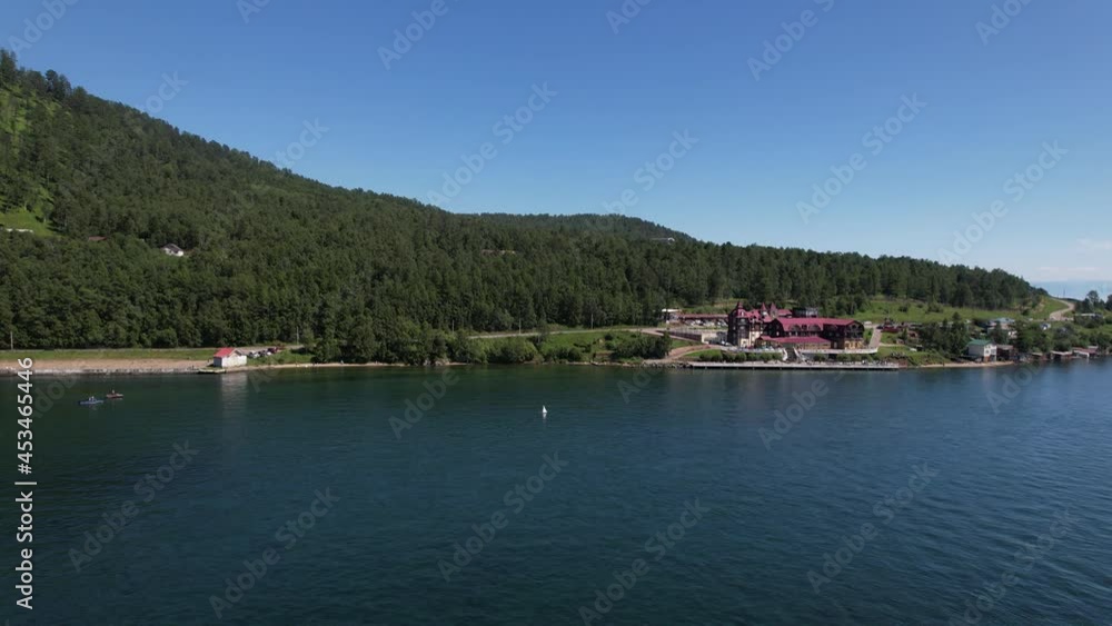 Lake Baikal is a marvelous blue jewel framed by scenic mountains and forests. Epic cinematic aerial view Lake Baikal. Aerial view of blue lake and green forests. Lake Baikal is a marvelous blue jewel framed by scenic mountains and forests. Epic cinematic aerial view Lake Baikal. Aerial view of blue lake and green forests.