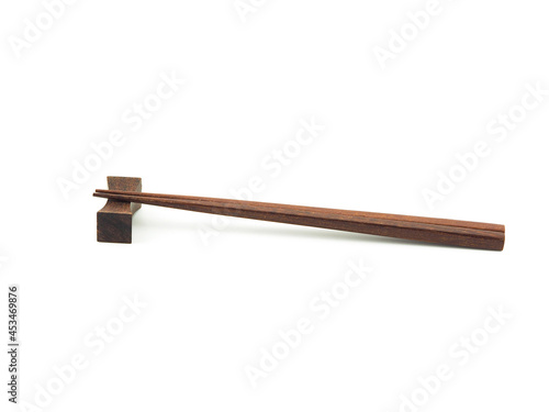 Brown wooden chopsticks on chopstick-rest isolated. Use for home or restaurant, food design. Kitchen accessory. Japanese style.