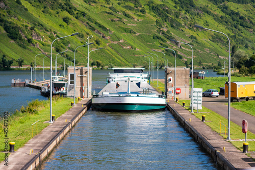 The photo shows a cargo ship at the lock on a river