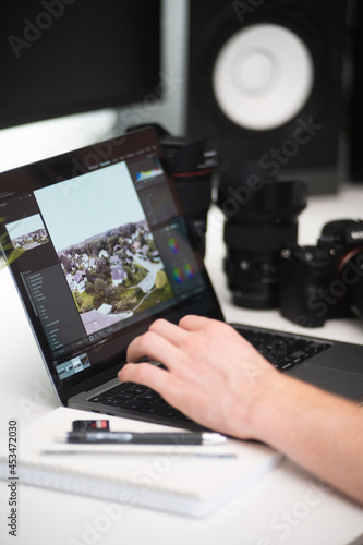 minimalistisches Homeoffice eines Fotografen mit einer grünen pflanze Kamera und objektiven