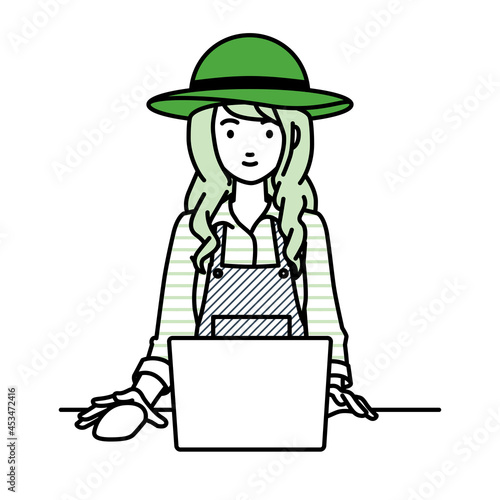 デスクで座ってPCを使っている農家の女性