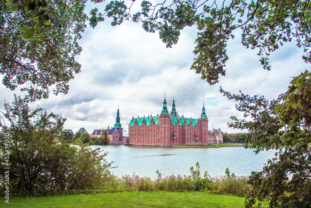 magical fascinating landscape landscape with lake and largest renaissance castle in Scandinavia Frederiksborg slot Castle near Copenhagen. Hillerod, Denmark. Popular tourist atraction.