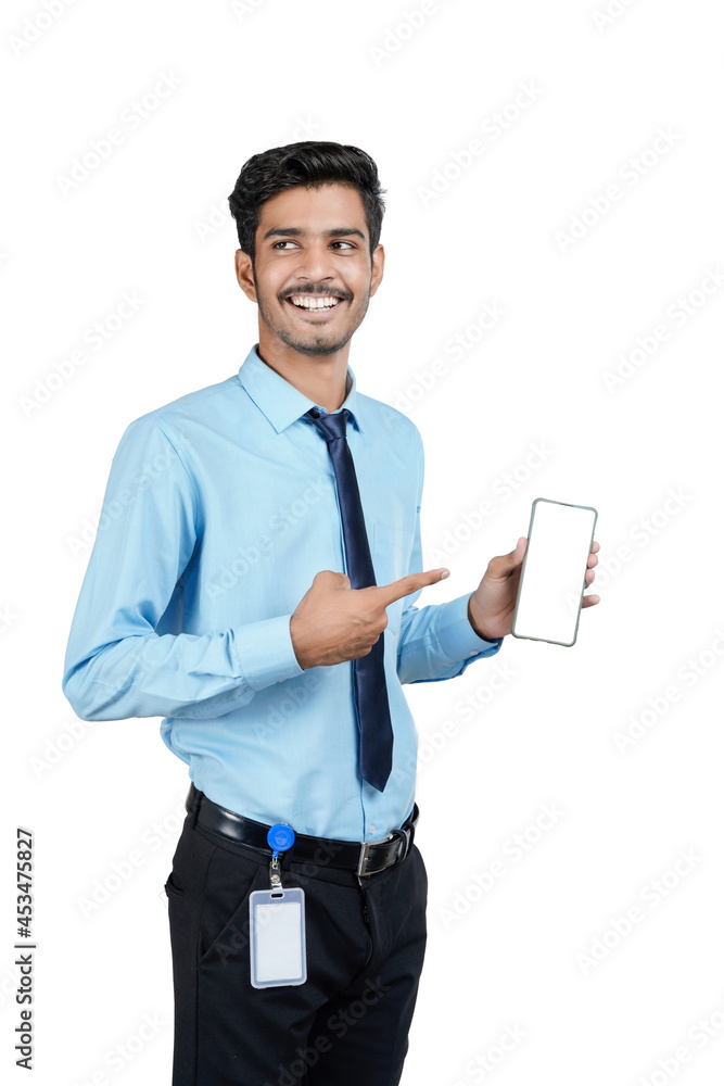Young indian officer or student showing smartphone screen on white background. Young indian officer or student showing smartphone screen on white background.
