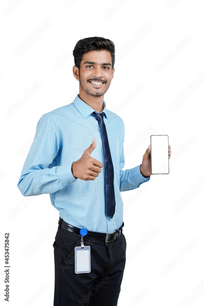 Young indian officer or student showing smartphone screen on white background. Young indian officer or student showing smartphone screen on white background.