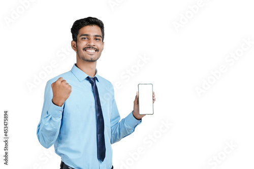 Young indian officer or student showing smartphone screen on white background.