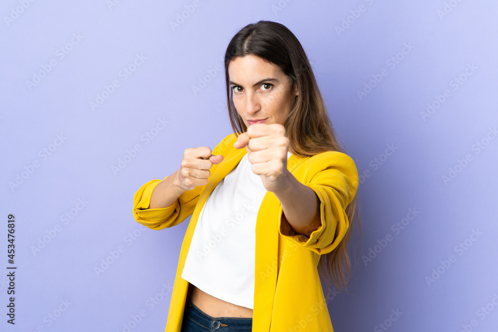 Young caucasian woman over isolated background with fighting gesture Young caucasian woman over isolated background with fighting gesture