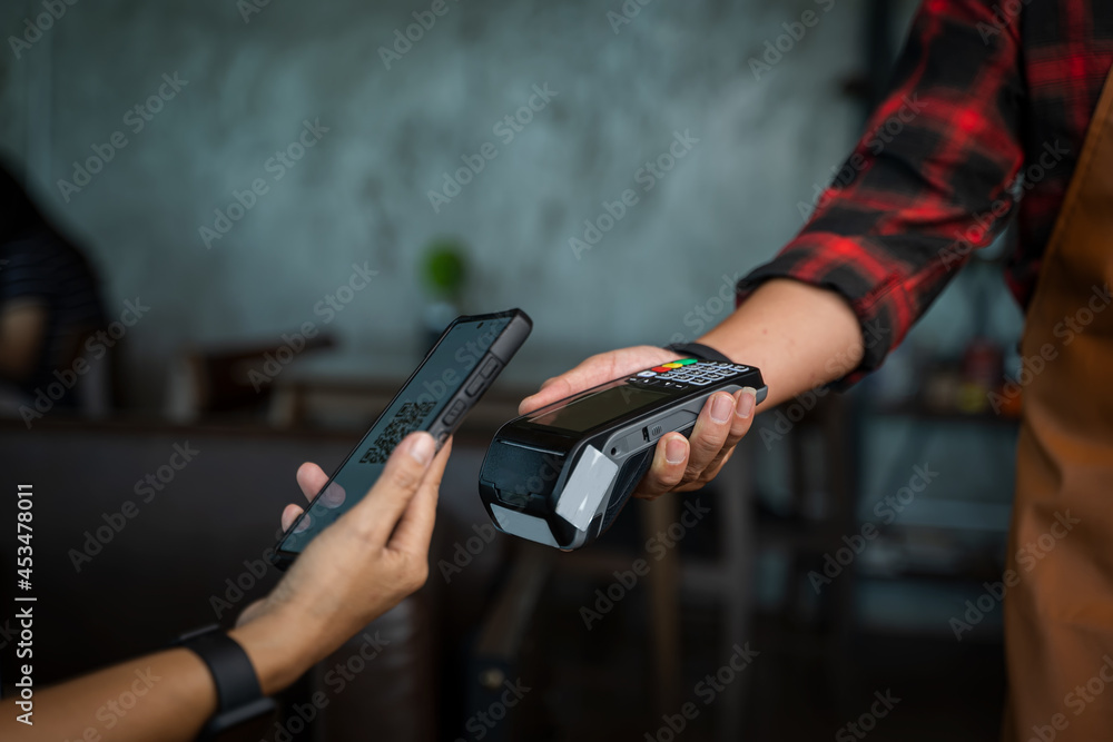 Close up woman hand holding using smartphone while making contactless payment at cafe,Mobile payment.