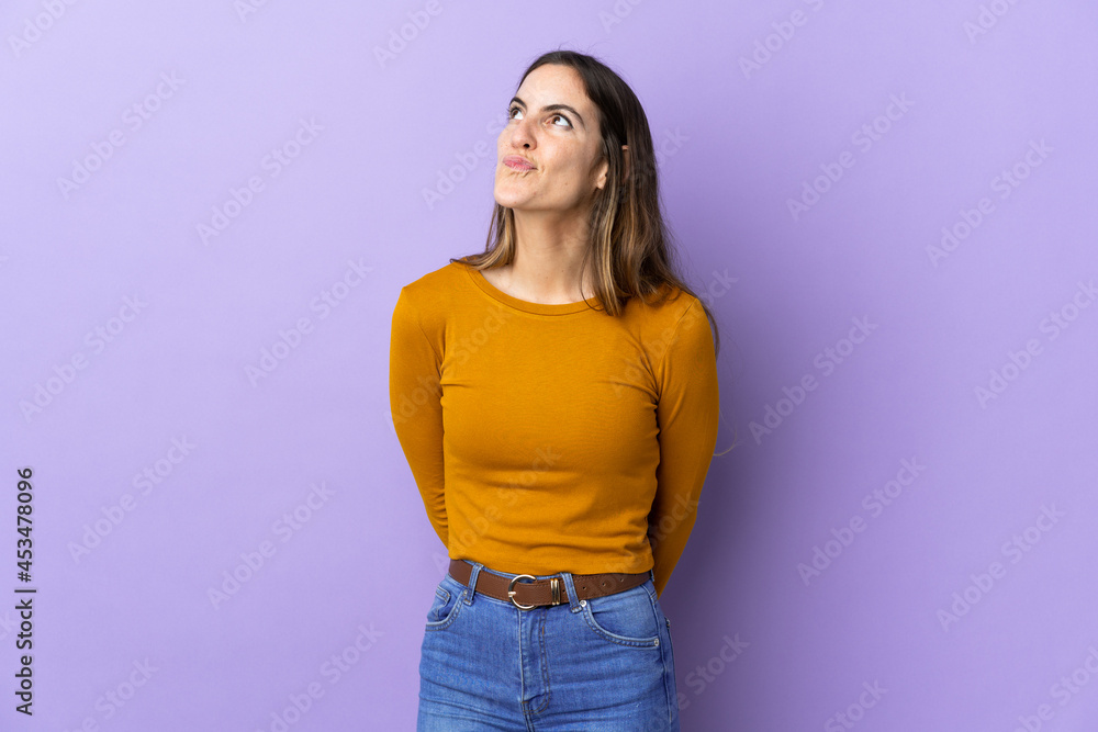 Young caucasian woman over isolated background and looking up Young caucasian woman over isolated background and looking up