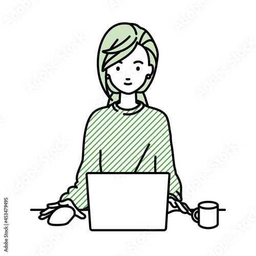デスクで座ってPCを使っているリモートワークの女性