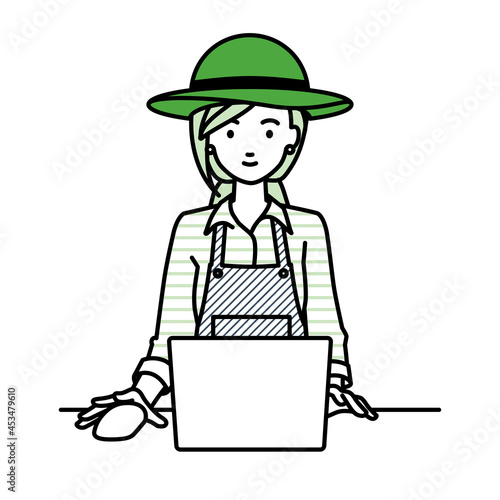 デスクで座ってPCを使っている農家の女性