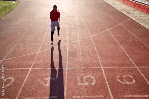 Fototapeta Naklejka Na Ścianę i Meble -  athletes sprinting.  man in sport clothes run at the running track in professional stadium