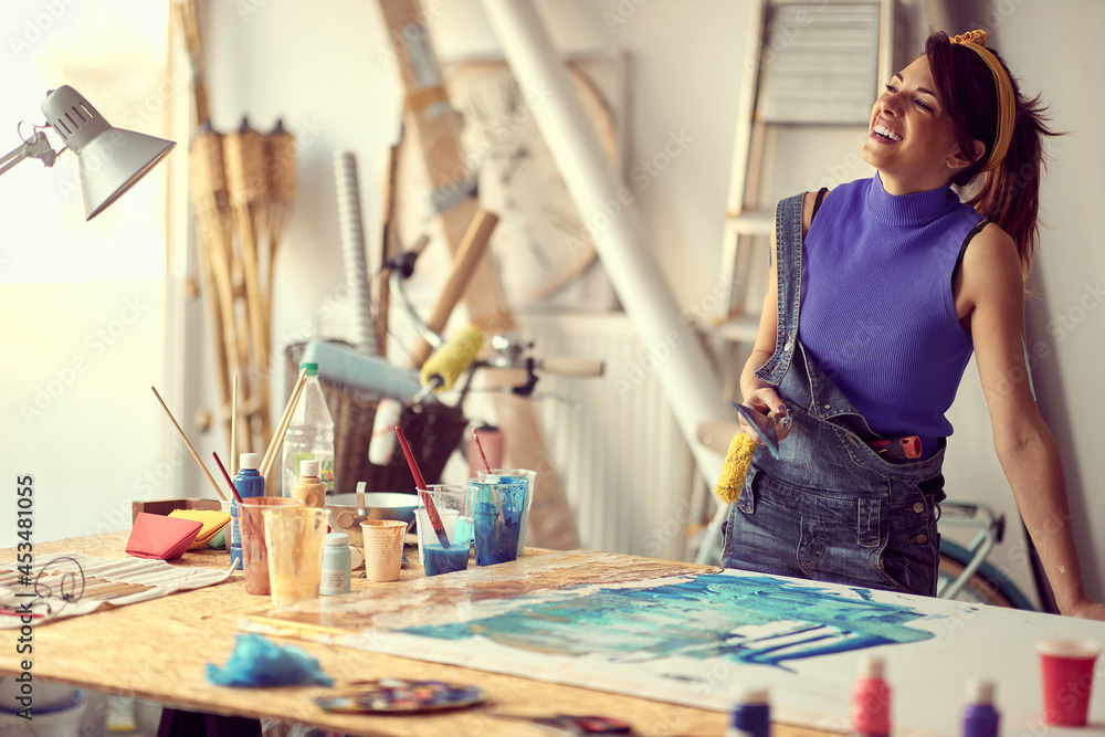 Fototapeta premium Happy female painter artist creating a new piece
