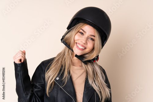 Russian girl with a motorcycle helmet isolated on beige background