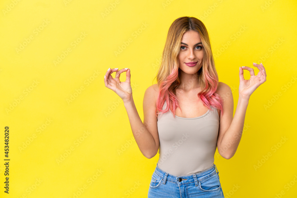 Young woman over isolated yellow background in zen pose Young woman over isolated yellow background in zen pose