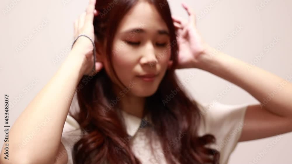 髪の毛を結ぶアジア人女性 髪の毛を結ぶアジア人女性