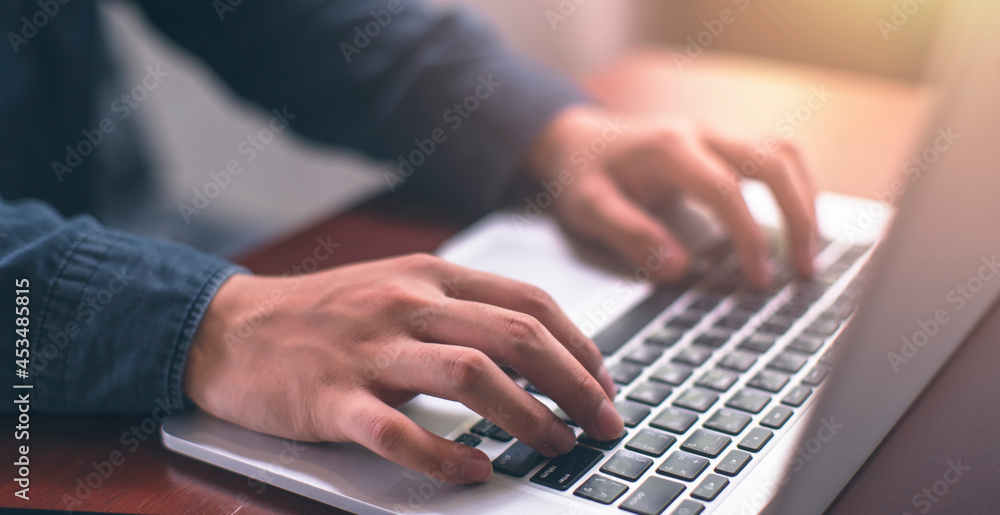 Young businessman is working on Laptop and Smartphone in coffee shop. stock business or work from home and concept. vintage tone Young businessman is working on Laptop and Smartphone in coffee shop. stock business or work from home and concept. vintage tone