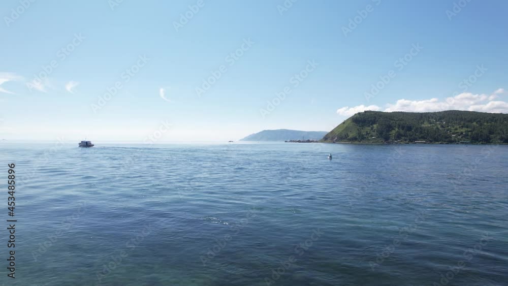 Lake Baikal is a marvelous blue jewel framed by scenic mountains and forests. Epic cinematic aerial view Lake Baikal. Aerial view of blue lake and green forests. Lake Baikal is a marvelous blue jewel framed by scenic mountains and forests. Epic cinematic aerial view Lake Baikal. Aerial view of blue lake and green forests.
