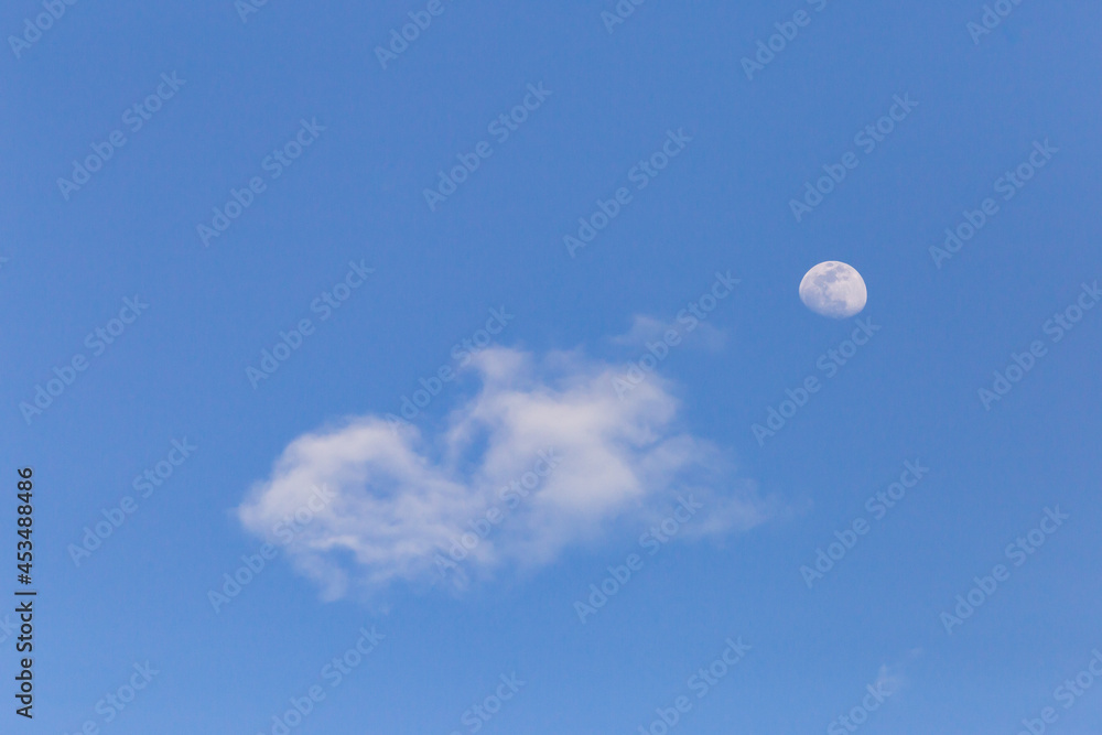 moon with white clouds blue background The afternoon moon has space for messages. moon with white clouds blue background The afternoon moon has space for messages.
