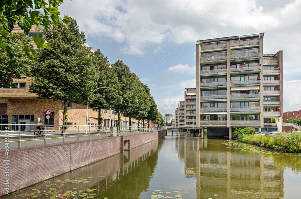 Zwolle, The Netherlands, August 14, 2021: apartment buildings and a row of trees reflecting in a modern version of a traditional Dutch canal