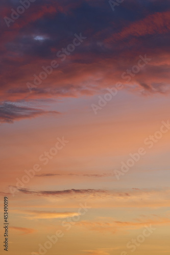  Beautiful evening blue sky at sunset with flaming bright light clouds. A warm summer evening at sunset. Bright sunset. 