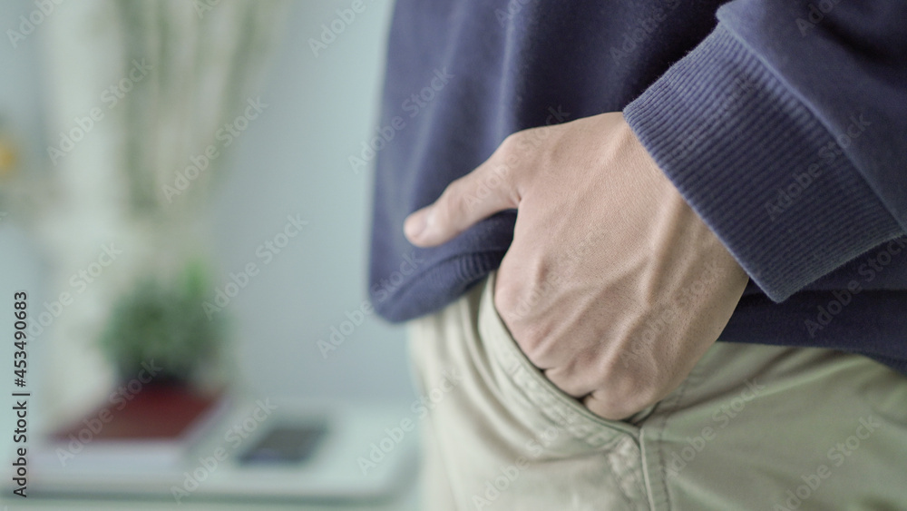 young asian man with cool hands in pants pocket