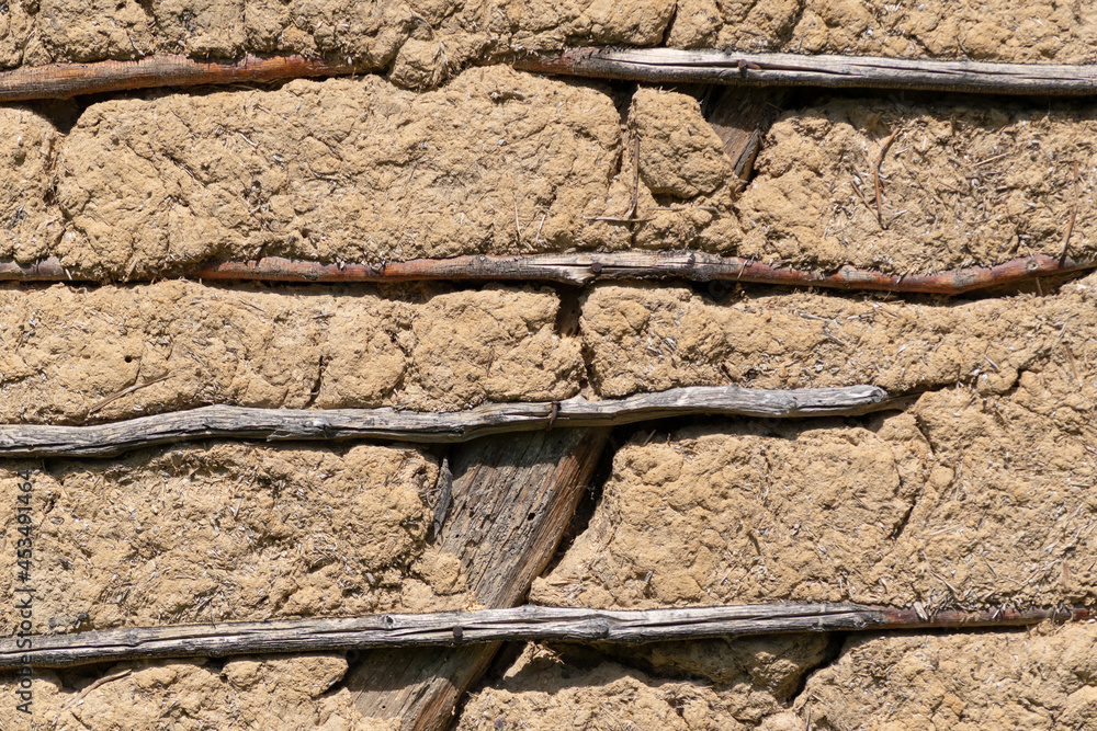 Fototapeta premium Wall made of mixture dirt, mud and wheat chaff supported with wooden sticks