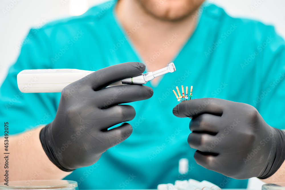 Close up of dentist hand with special tool for removing nerve from tooth. Dentist orthopedist tools. Close up of dentist hand with special tool for removing nerve from tooth. Dentist orthopedist tools.
