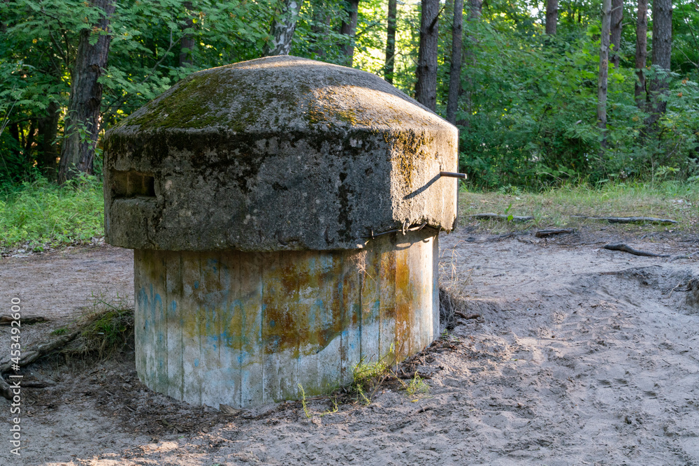 Old small concrete infantry sniper post in the woods of Hel, Poland. Old military fortification from World War Two and Cold War. Guard outpost buried deep in the ground. Old small concrete infantry sniper post in the woods of Hel, Poland. Old military fortification from World War Two and Cold War. Guard outpost buried deep in the ground.