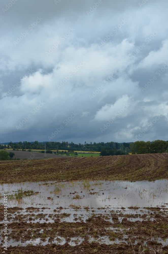 Schwarzer Wolkenhimmel über Ackerlandschaft nach dem Unwetter - Überschwemmung
