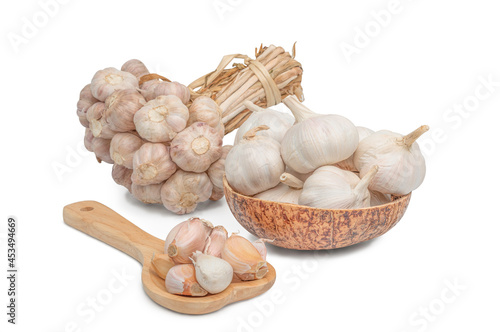 Garlic cloves and Bulb in wooden bowl isolated on white balckground. photo