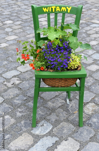 Stuhl mit Blumen und der Aufschrift: "Witamy"