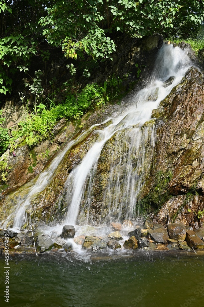 Naklejka premium Beautiful small waterfall with a rock in nature. Brno castle Spilberk.