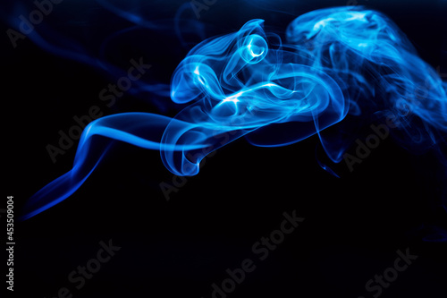 Abstract colored smoke moves on dark background. Wallpaper. Personal vaporizers fragrant steam. Concept of alternative non-nicotine smoking. E-cigarette. Texture. Design elements.