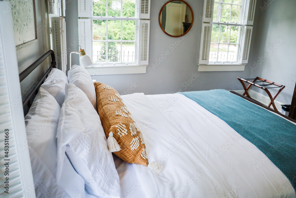 A guest bedroom with a queen sized bed and nightstand at a short term rental small cottage style house
