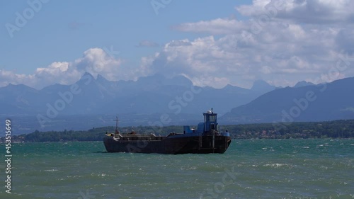 Working ship rocking in the waves of Lake Geneva on a sunny day. Slow motion movie shot August 28th, 2021, Nyon, Switzerland.