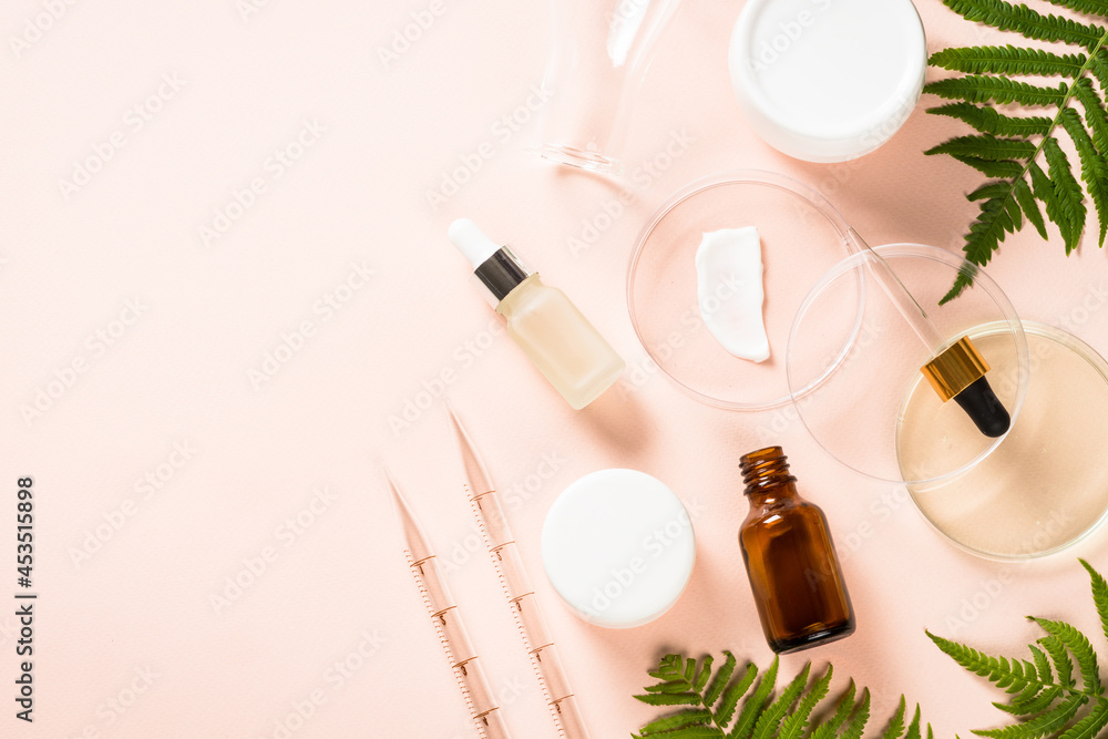 Cosmetic laboratory concept . Glass petri dish with natural cosmetic products and plants. Flat lay image.
