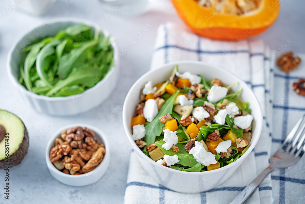Roasted pumpkin avocado arugula goat cheese salad in a plate Roasted pumpkin avocado arugula goat cheese salad in a plate