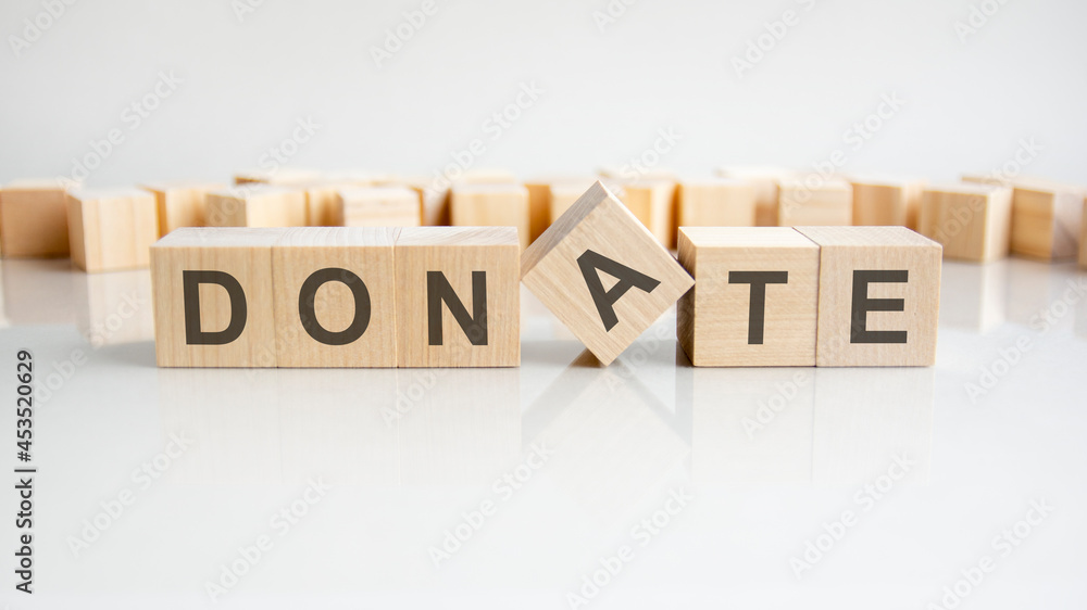 Donate text on a wooden blocks, gray background
