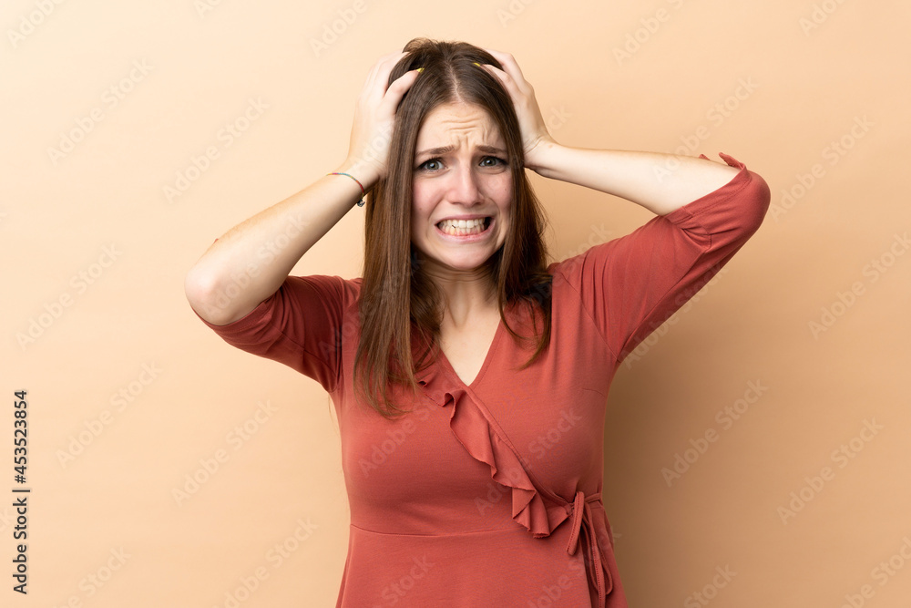 Fototapeta premium Young caucasian woman isolated on beige background doing nervous gesture